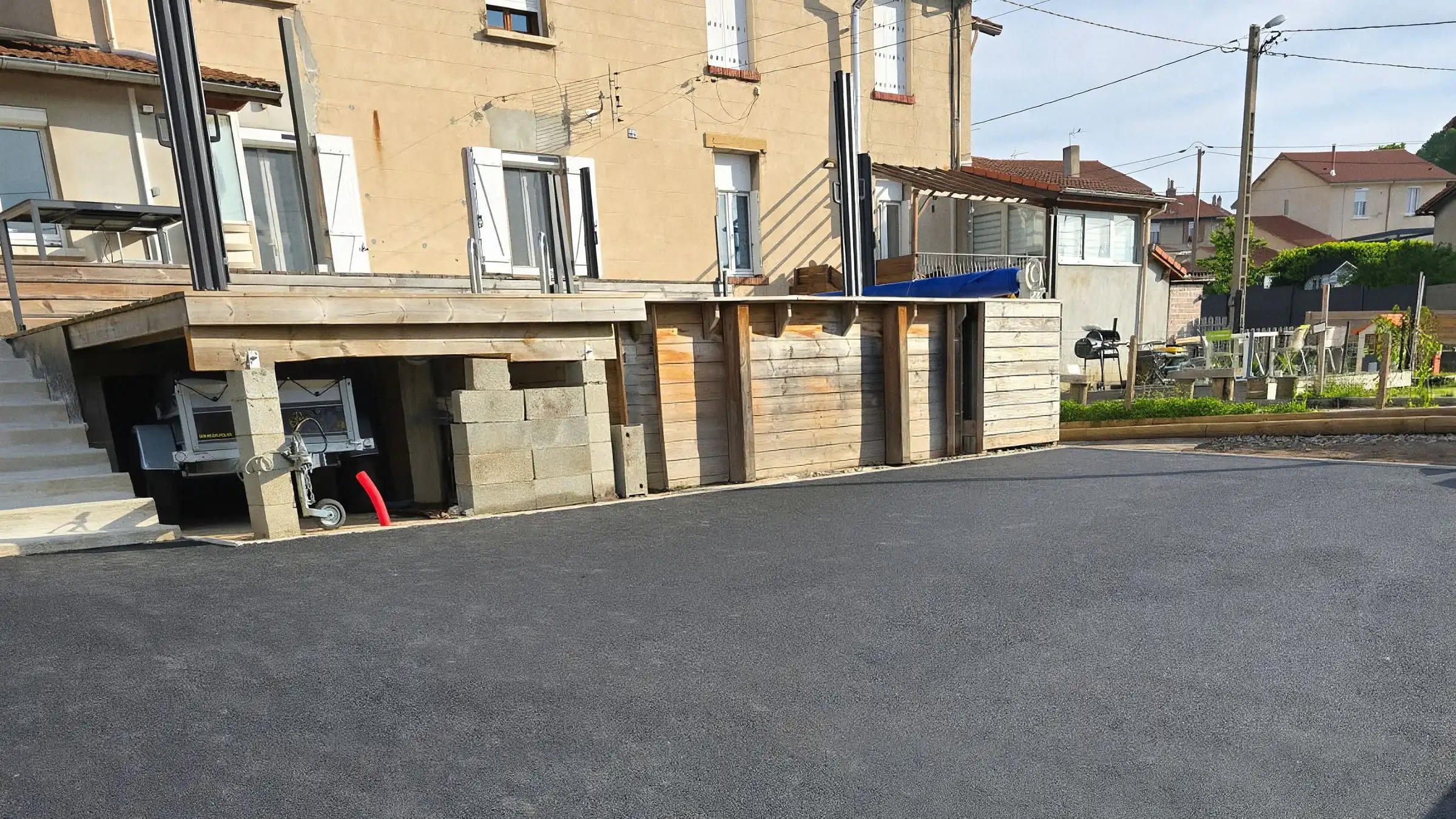Cour de maison de ville entièrement revêtue d'enrobé neuf, caniveau à grille en bordure